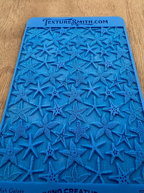 A textured blue mat covered with raised starfish patterns.