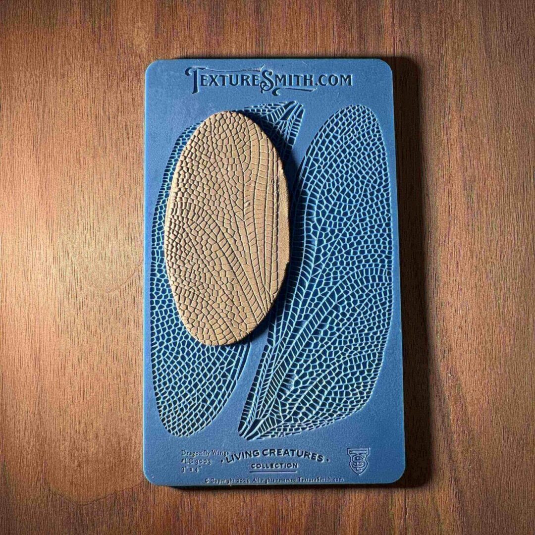 Vintage blue board with a textured oval and leaf design.