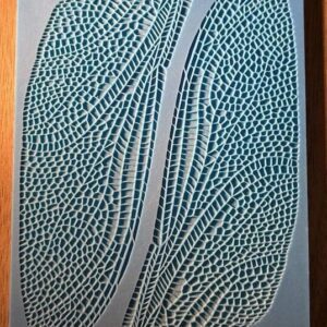Close-up of two textured, leaf-like blue patterns on a white background.