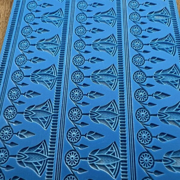 Blue fabric with intricate black tribal patterns.