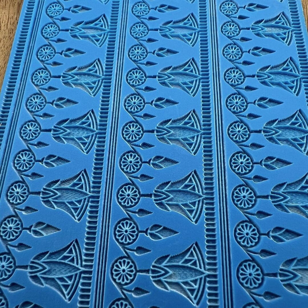 Blue fabric with intricate black tribal patterns.