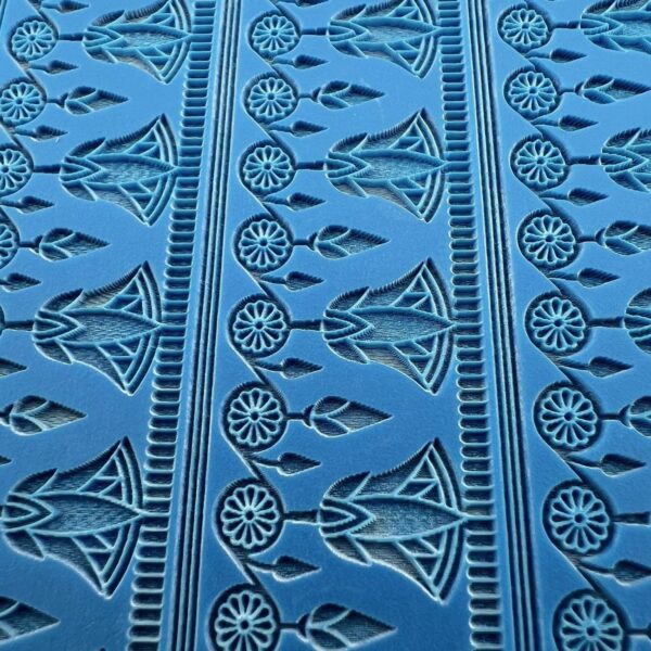 Close-up of blue fabric with intricate black geometric and floral patterns.