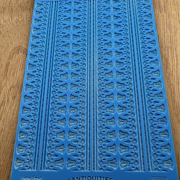 Blue textured rubber mat with intricate patterns on a wooden surface.