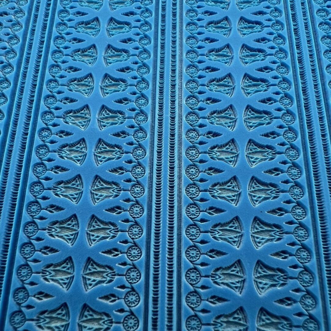 Intricate blue patterned textile with symmetrical designs.