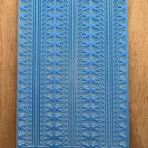 Close-up of a blue textured book cover with intricate patterns.