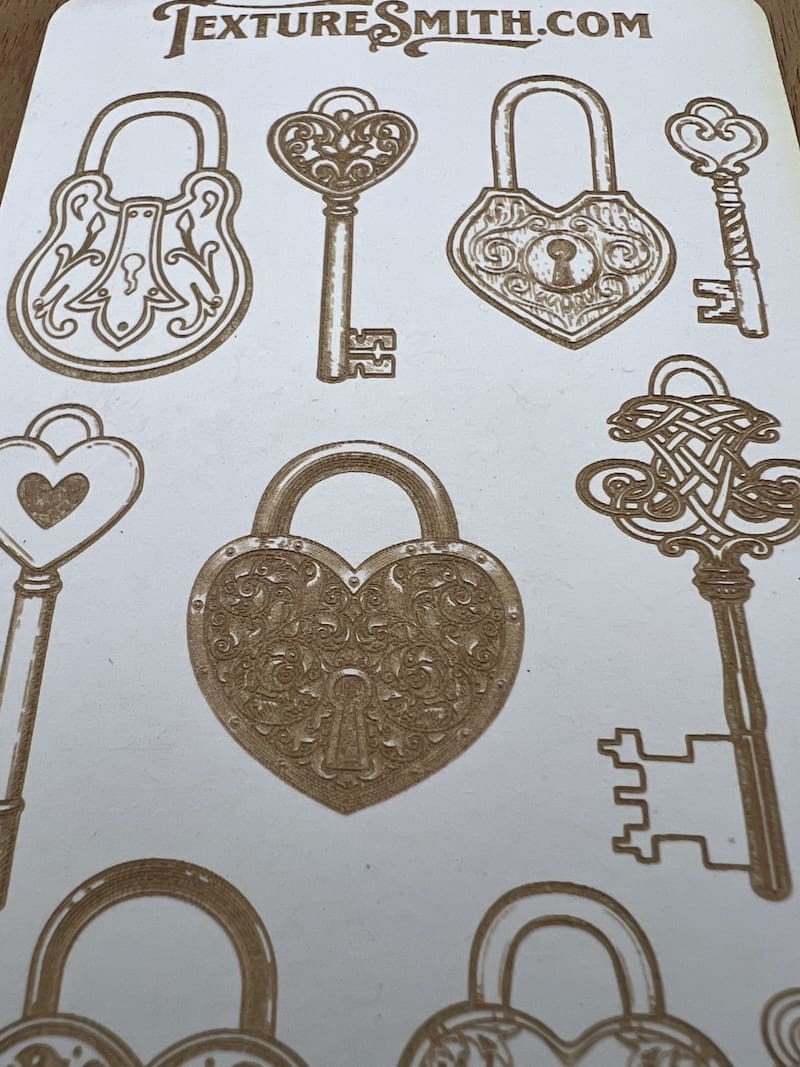 Golden vintage keys and locks with heart motifs on a white background.
