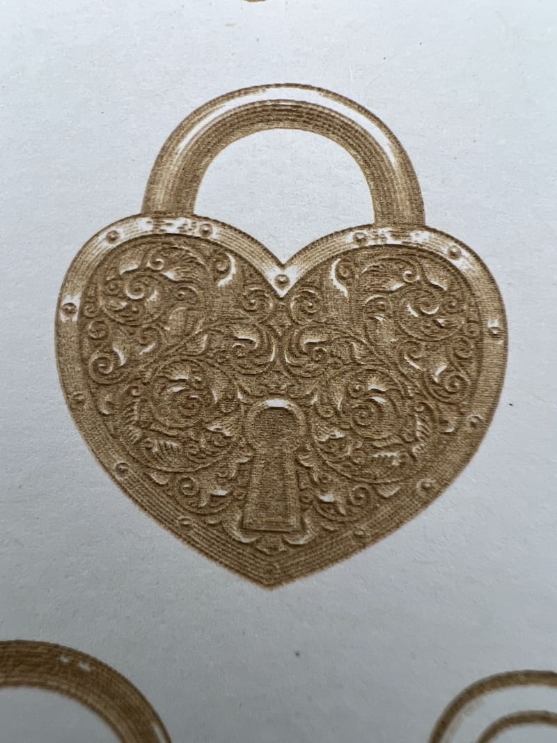 A heart-shaped padlock with intricate floral designs.