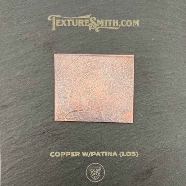A copper sheet with a patina finish on a textured background.