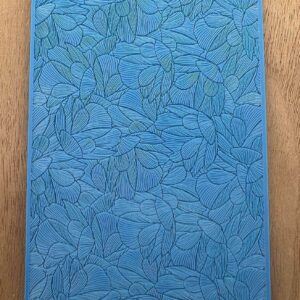 Blue notebook with embossed leaf pattern on a wooden surface.