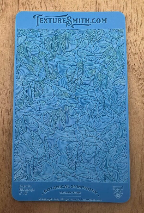 Blue notebook with embossed leaf pattern on a wooden surface.