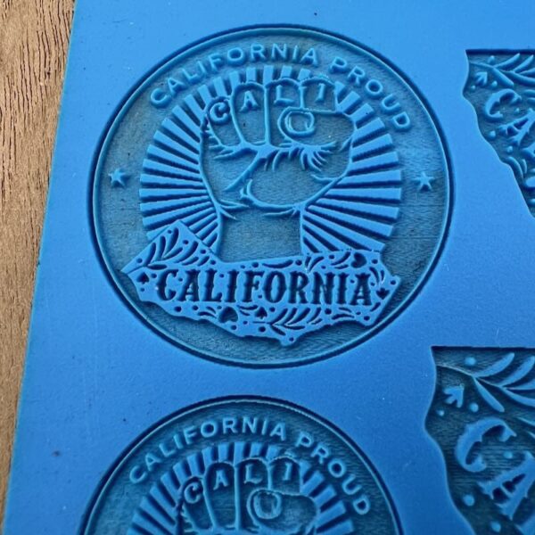 Embossed California-themed designs with a raised fist and rays on blue material.