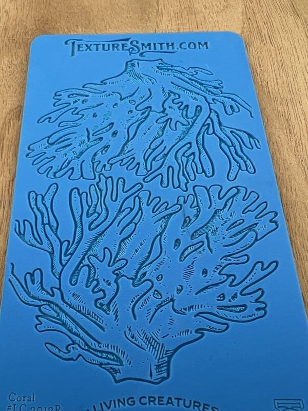 Blue paper with intricate coral-like line art designs.