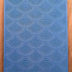 Blue crochet fabric with intricate scalloped patterns.