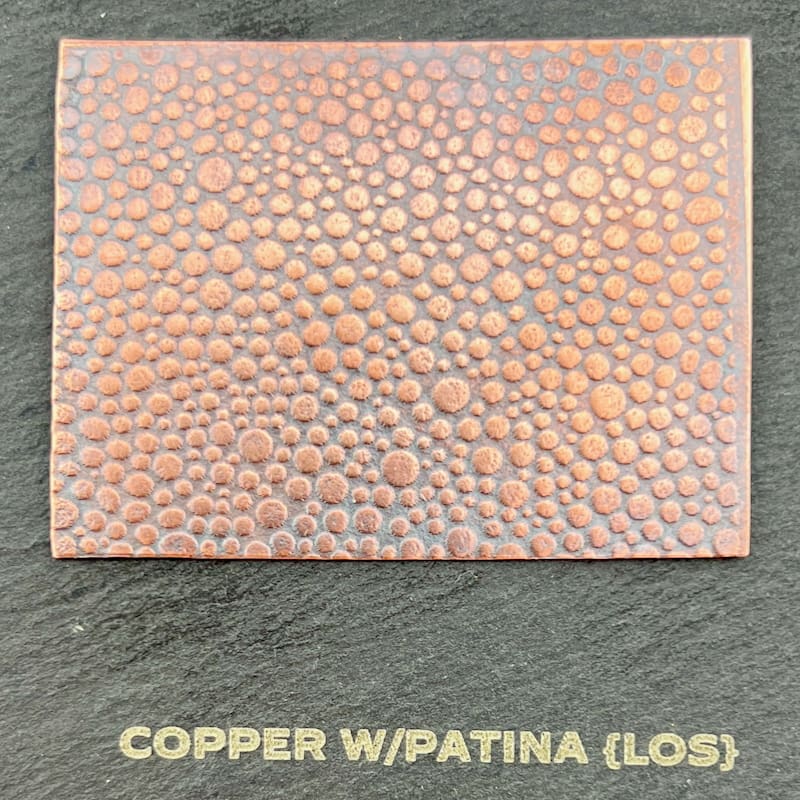 Copper sheet with patina and glossy finish showing textured surface.