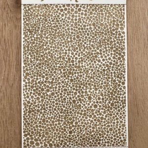 Brown and white leopard print fabric laid on a wooden surface.