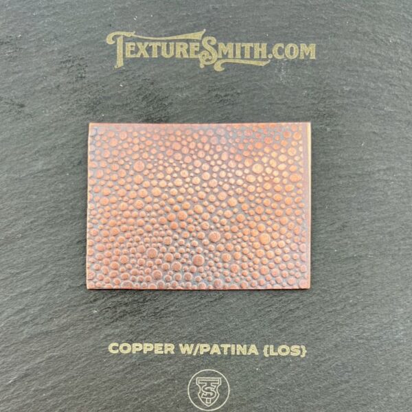 Copper sheet with wrinkled texture on a dark background.