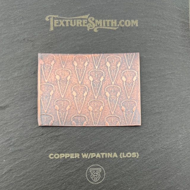 Copper patina tile sample with intricate geometric patterns.