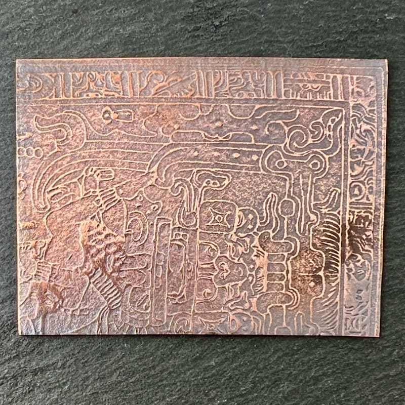 Intricately carved ancient script on a rectangular stone tablet.