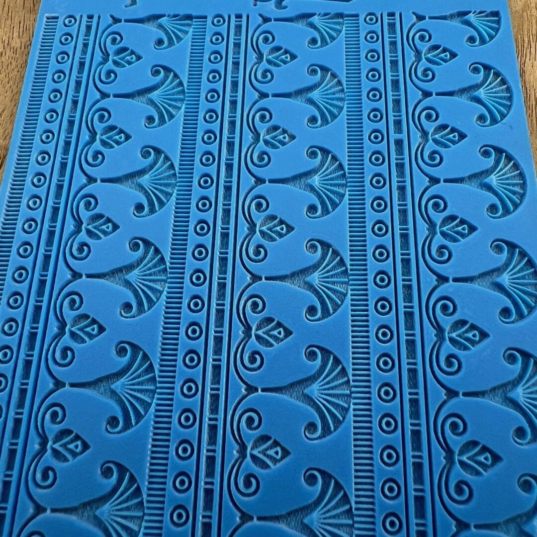 Blue fabric with intricate black floral and geometric patterns.
