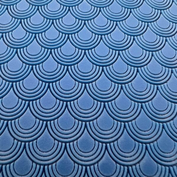 Blue fabric with a repeating scallop pattern.