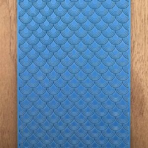 Close-up of a blue textured surface with a diamond pattern on wood.