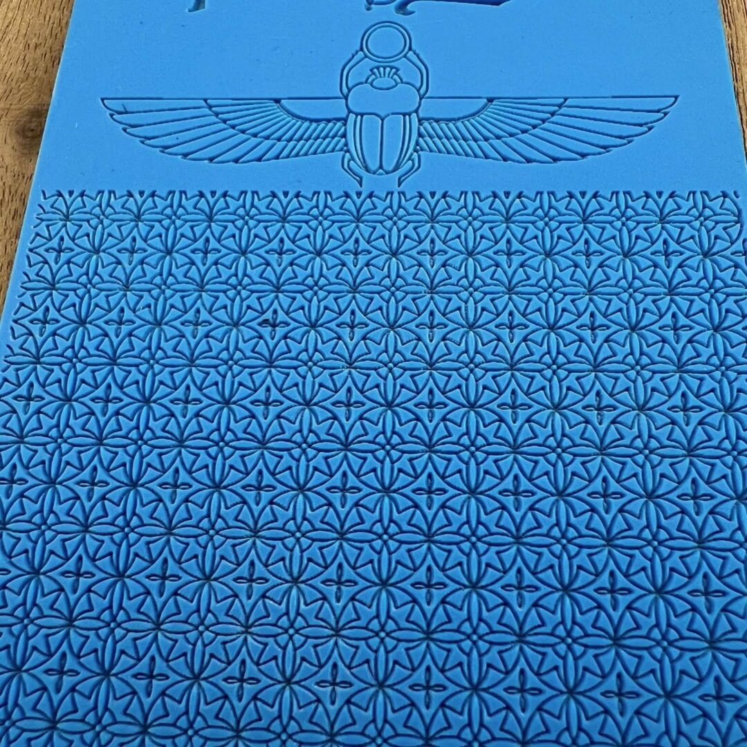 A blue sheet with repeated swastika patterns and a winged symbol at the top.