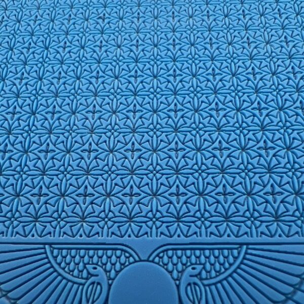 Intricate blue patterned surface with symmetrical geometric and floral designs.
