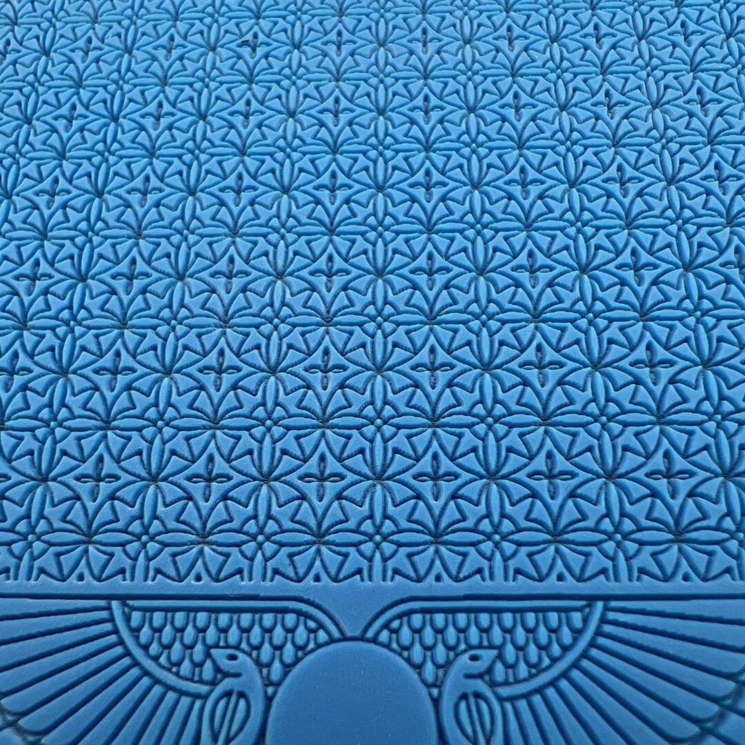 Intricate blue patterned surface with symmetrical geometric and floral designs.