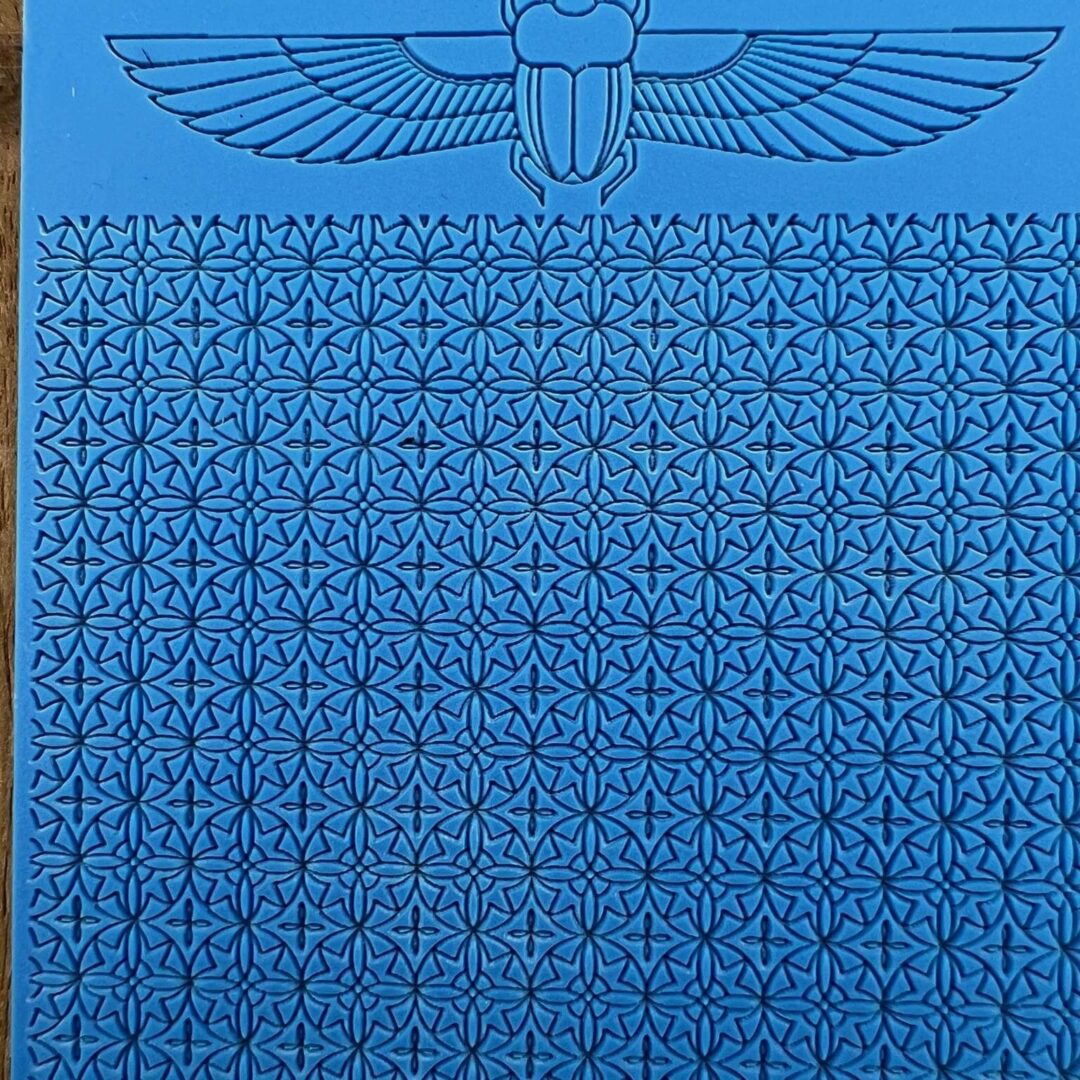 Ancient Egyptian-style wall with hieroglyphics and winged sun disk symbol.