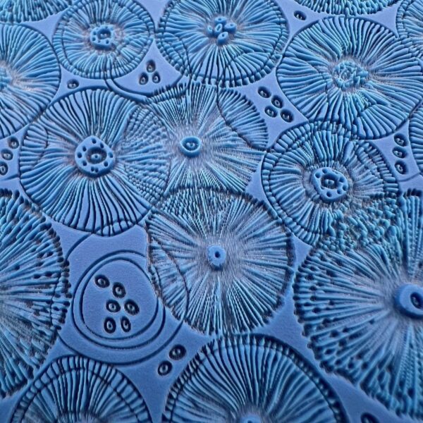 Close-up of blue glass plates with intricate radial patterns.