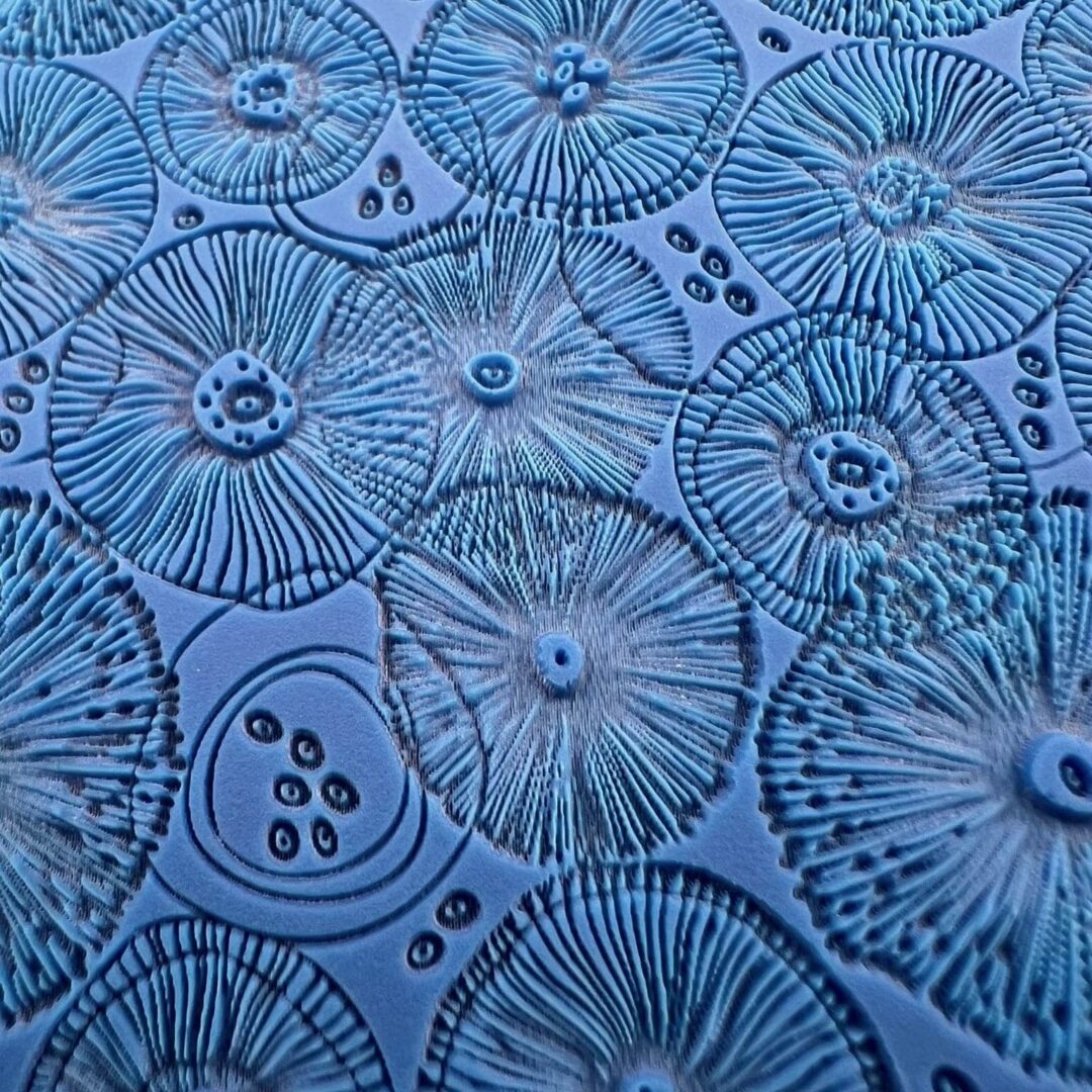 Close-up of blue glass plates with intricate radial patterns.