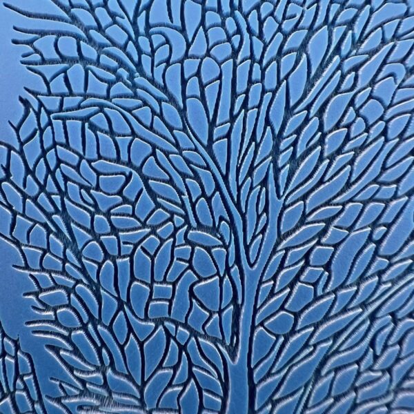 Close-up of intricate blue glass artwork with leaf-like patterns.