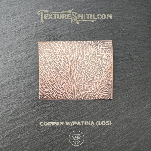 Close-up of copper surface with patina texture on a dark background.