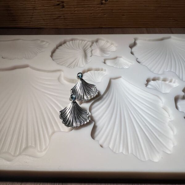 Detailed white ceramic wall art with leaf and flower patterns.