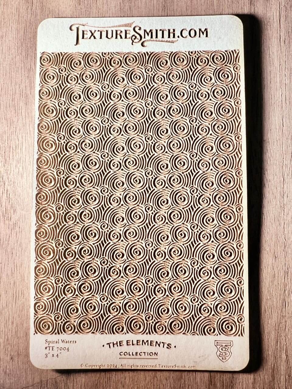 Intricate rectangular mat with repeating geometric patterns on a wooden surface.