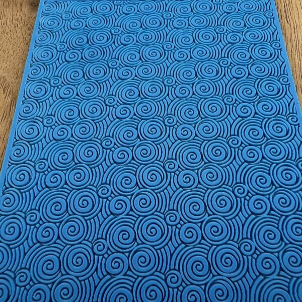 Blue mat with intricate circular spiral patterns.