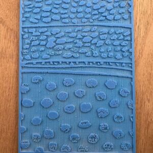 Close-up of a blue textured mat with various raised patterns.