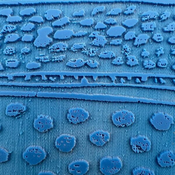 Close-up of a blue fabric with textured circular patterns.