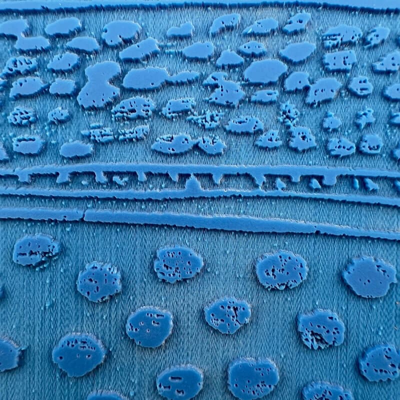 Close-up of a blue fabric with textured circular patterns.