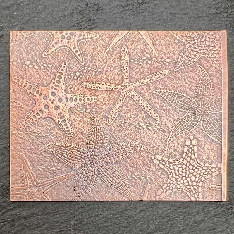 Intricate textured artwork with starfish motifs on a beige canvas.