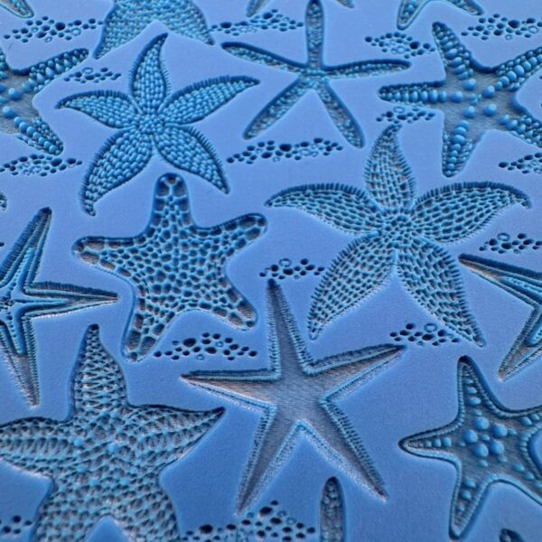 A collection of blue starfish on a textured surface.