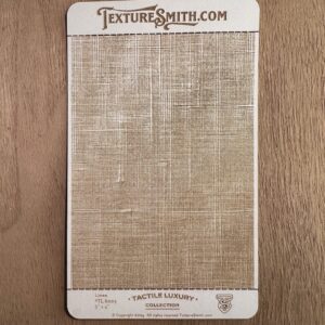 A textured fabric sample card from TextureSmith.com laid on wood.