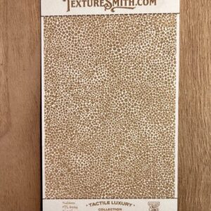 Beige textured sheet with a small pebble pattern on wood surface.