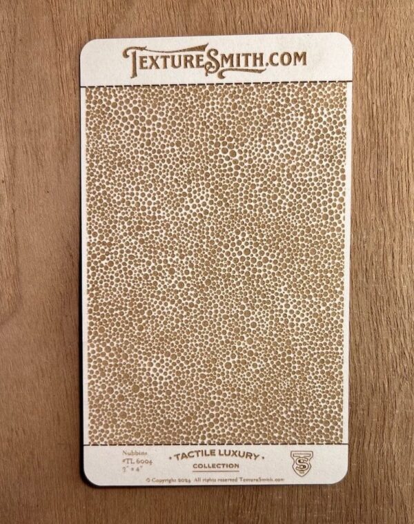 Beige textured sheet with a small pebble pattern on wood surface.