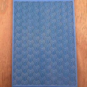 A blue textured book cover with a repeating geometric pattern.