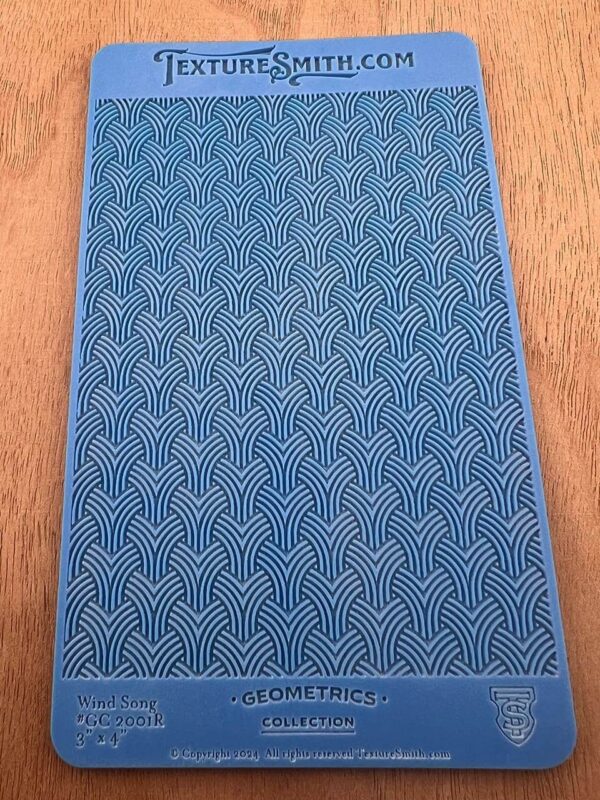 Textured blue fabric with a repeating geometric pattern.