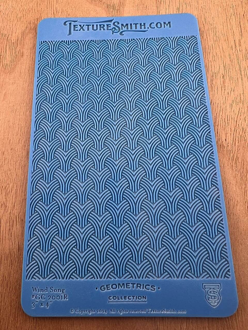Textured blue fabric with a repeating geometric pattern.