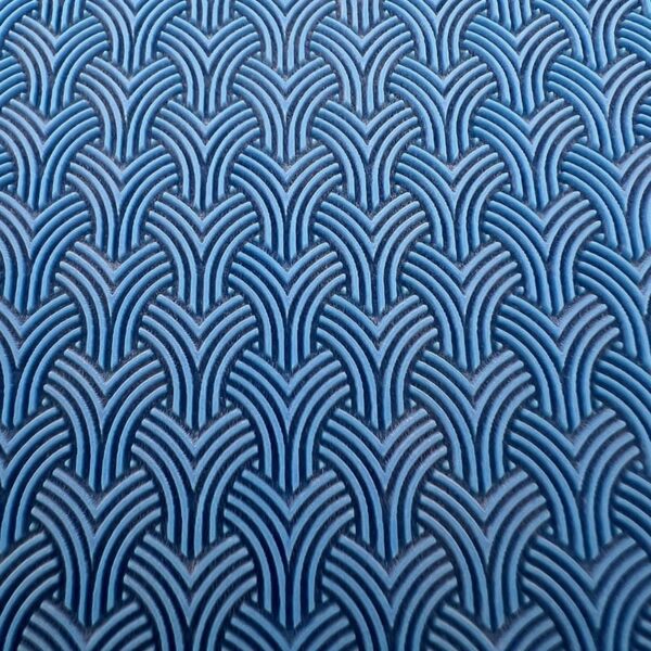 Blue fabric with a repeating geometric pattern of interlocking arches.