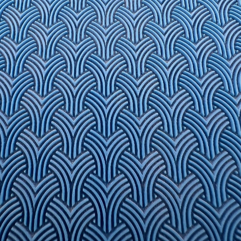 Blue fabric with a repeating geometric pattern of interlocking arches.