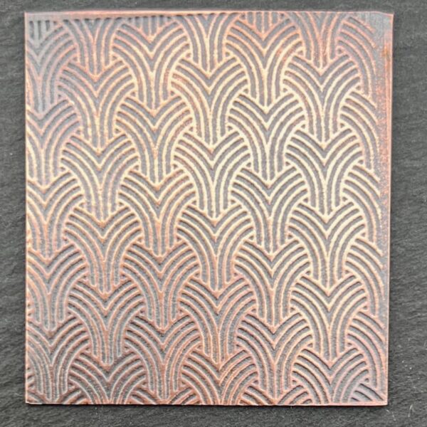 Intricate patterned ceramic tile with repeating curved design.
